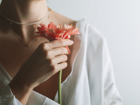 Close up of woman holding an orange flower