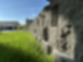 Stone retaining wall with fresh green lawn, installed for erosion control and landscape structure by Blue Bird Irrigation & Landscaping in Montana.
