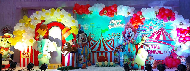 Unicorn and rainbow-themed birthday backdrop with balloons and colorful props.