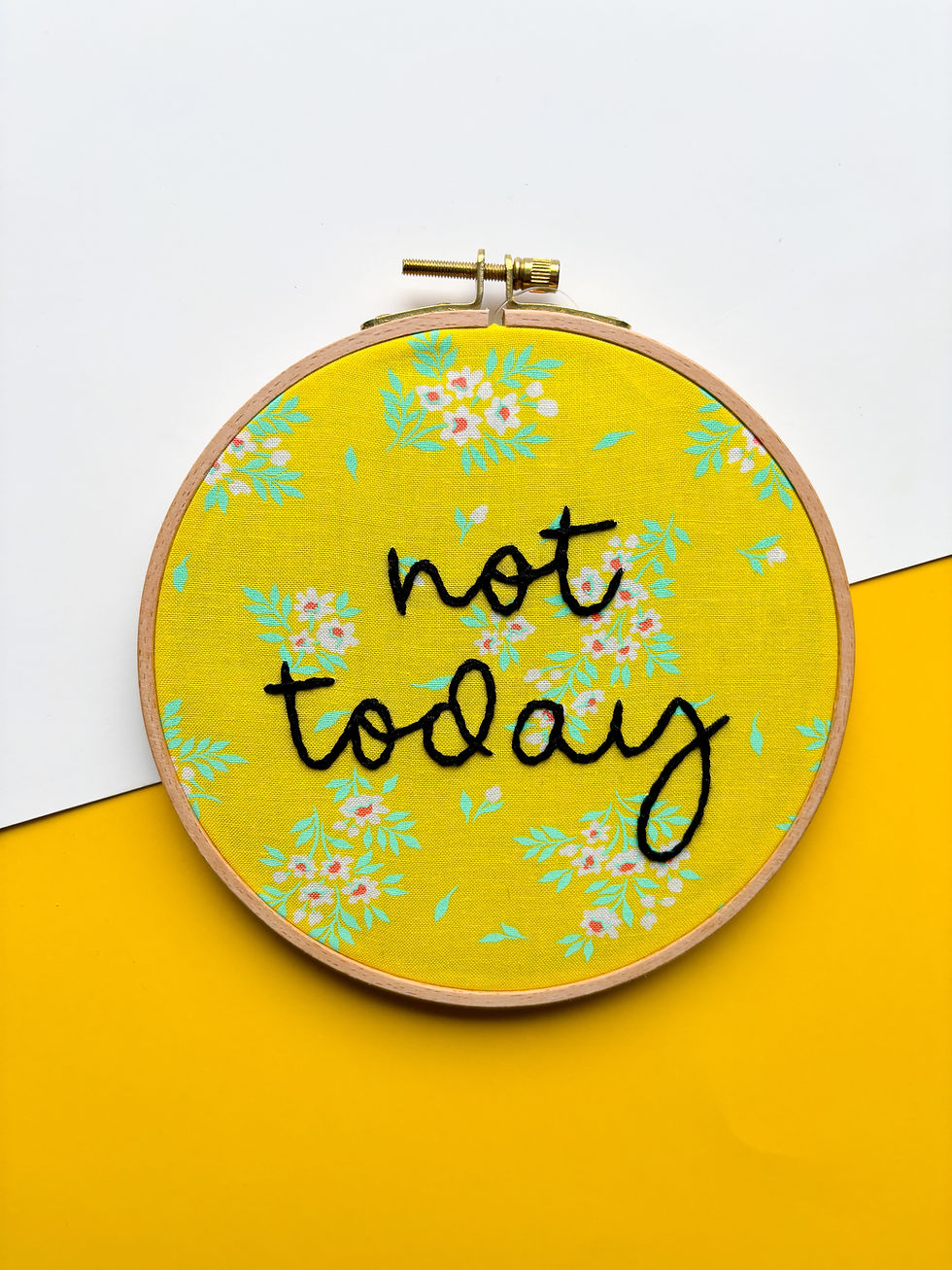 Yellow embroidery hoop with the words "not today" on the fabric.