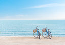Two bicycle at the beach on blue sky.jpg
