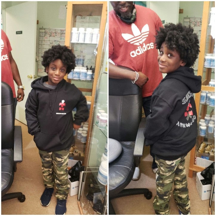 Young boy modeling a black hoodie and camo pants