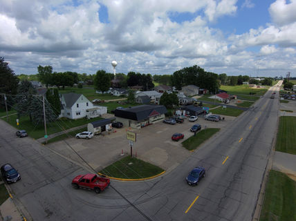 Aerial view of a small town, road, cars, gas station, and water tower.