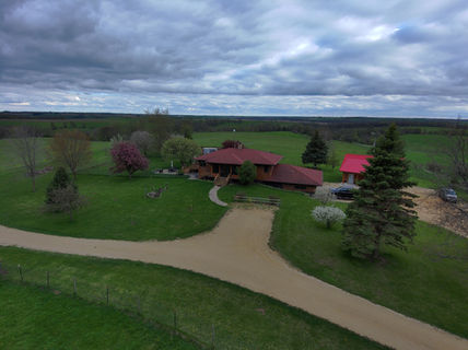 Aerial view of a large house and property under a cloudy sky
