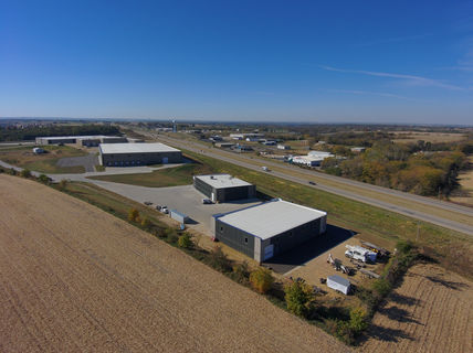 Aerial view of commercial buildings and highway in rural landscape