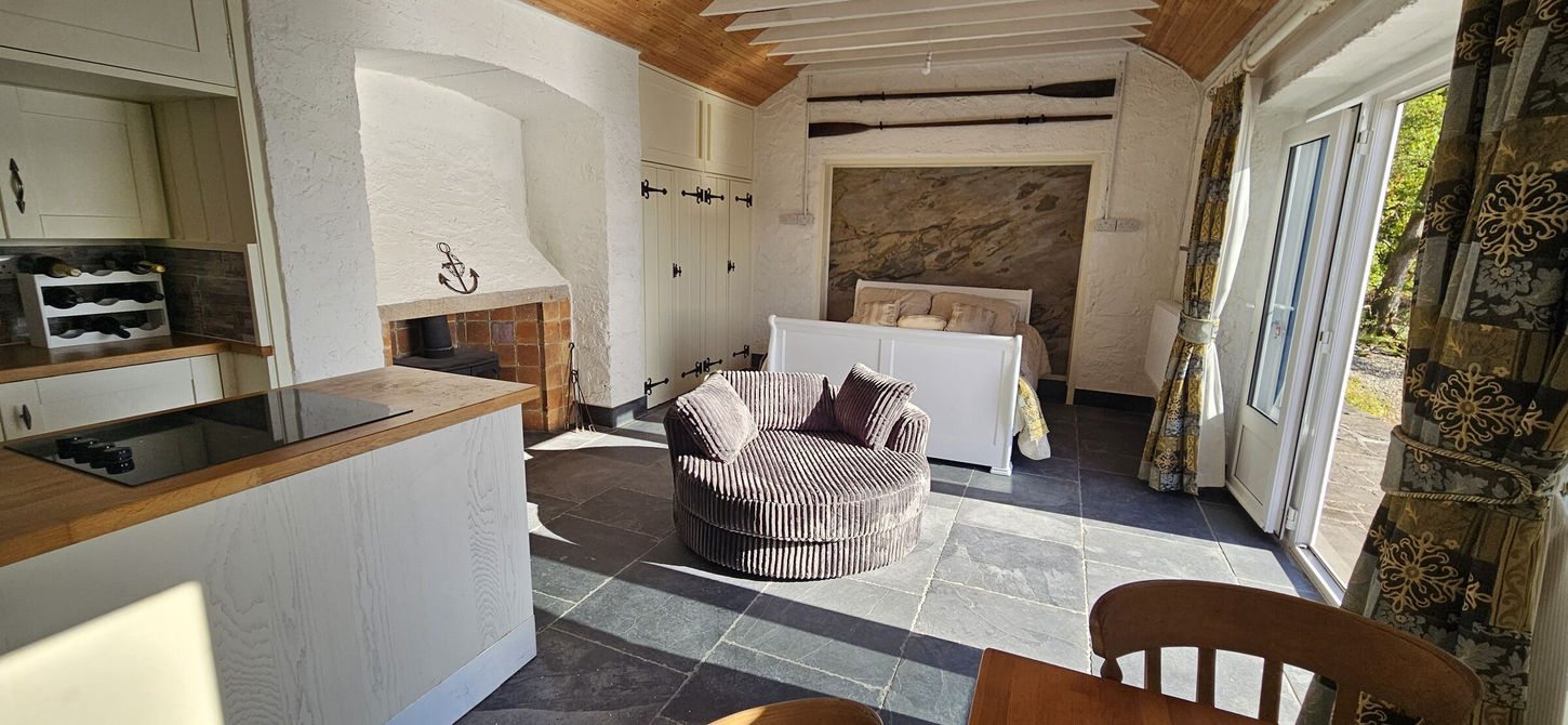 Living space with kitchen, love seat and slate floor