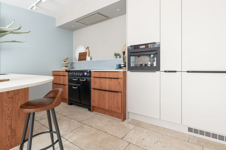 Maatwerk keuken, keuken op maat, maatwerkmeubel, houten keuken gecombineerd met lichte fronten hoge kastenwand, hoge kastenwand keuken,  keuken met afgerond blad, organisch gevormde keuken, rond barblad, ovaal barblad, keuken met ovale bar, keukennis met fortnuis, keukennis met blauwe tegeltjes, kitkat tegels, grafische tegelwand, lichtblauwin je interieur, wandtegels met wandplanken, displaywand in keuken, Nordic kitchen, Scandinavian kitchen, Hygge, zandkleur, Dun keukenblad, Dekton keukenblad, Eijffinger behang, Woonkeuken, leefkeuken, highend keuken, highend living, Muuto fibr chair, Hay Nelson lampen Witte hanglampen, lichtplan, spotrails in keuken