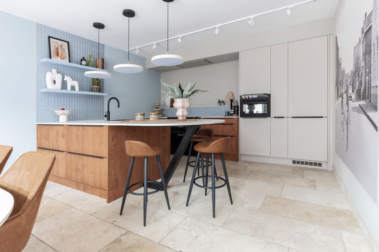 Maatwerk keuken, keuken op maat, maatwerkmeubel, houten keuken gecombineerd met lichte fronten hoge kastenwand, hoge kastenwand keuken,  keuken met afgerond blad, organisch gevormde keuken, rond barblad, ovaal barblad, keuken met ovale bar, keukennis met fortnuis, keukennis met blauwe tegeltjes, kitkat tegels, grafische tegelwand, lichtblauwin je interieur, wandtegels met wandplanken, displaywand in keuken, Nordic kitchen, Scandinavian kitchen, Hygge, zandkleur, Dun keukenblad, Dekton keukenblad, Eijffinger behang, Woonkeuken, leefkeuken, highend keuken, highend living, Muuto fibr chair, Hay Nelson lampen Witte hanglampen, lichtplan, spotrails in keuken