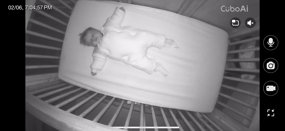 Baby sleeping on his back in a Magic Merlin Sleepsuit with arms resting out to the sides