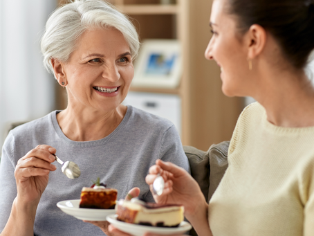 Two women talking and enjoying cake — everyday conversation in a natural setting.