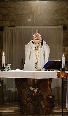 priest%20lifting%20goblet%20while%20standing%20beside%20table_edited.jpg