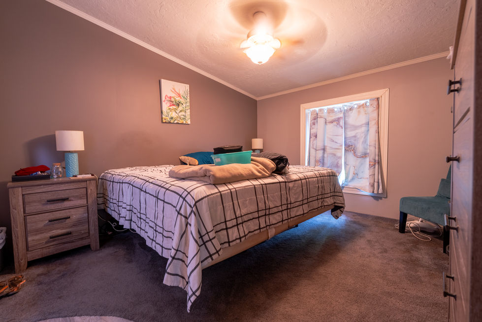 Primary bedroom in Spencer Indiana home with large windows and carpet flooring.