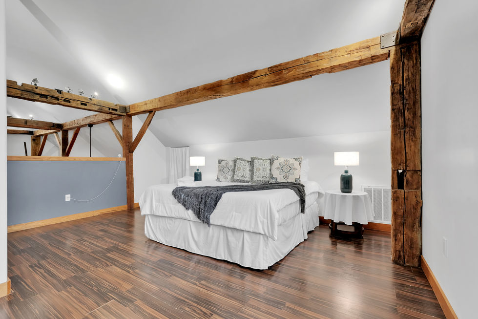 Cozy bedroom with wooden beams and modern decor.