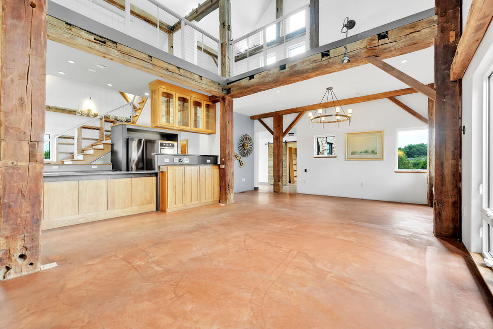 Spacious, modern interior with wooden beams and open layout.