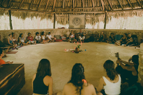 Small group seated in a circle inside the maloca during an ayahuasca ceremony at Madre Verde.