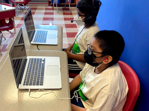 Estudiante niño sentado en la computadora portátil.