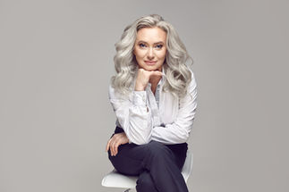 Mature Woman posing with naturally grey and white hair down around her shoulders up