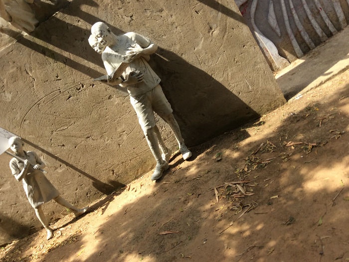 Standing figures in a historical sculpture display at Nkyimkyim Museum in Ada