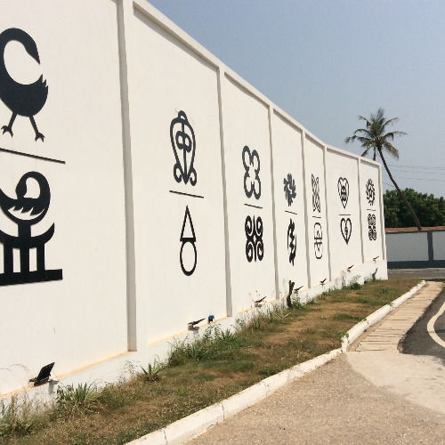 Adinkra symbols on a roadside wall during an Accra city tour