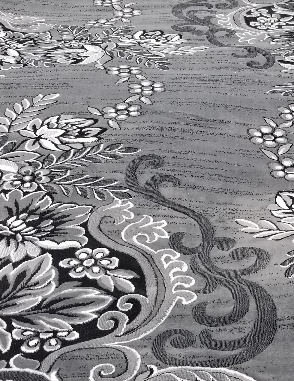 Contemporary rectangular rug with a repeating grey and white floral pattern, ideal for a minimalist living room. 