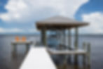 Custom-built waterfront dock with a covered boat lift, extended pier, and premium marine construction overlooking expansive water views.