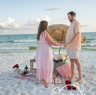 surprise proposal in 30A captured discreetly, photographer shooting from a hidden vantage point as he kneels in the sand