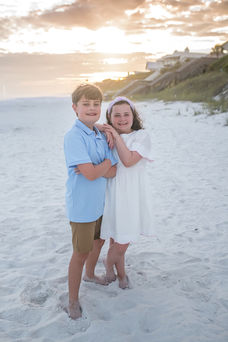Children collecting seashells during a family session showcasing where to buy heirloom art photography prints in 30A Florida.