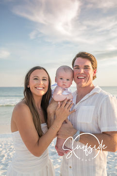 Happy family of three laughing on the beach during a sunset session, showcasing photography in Seaside Florida. Capturing genuine moments.