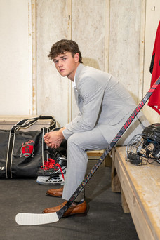 Senior Portraits of a senior guy gripping his hockey stick intensely on the rink for Envisions Photography Studio.