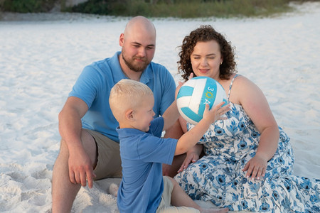 Growing family celebrating pregnancy during affordable mini sessions in 30A.