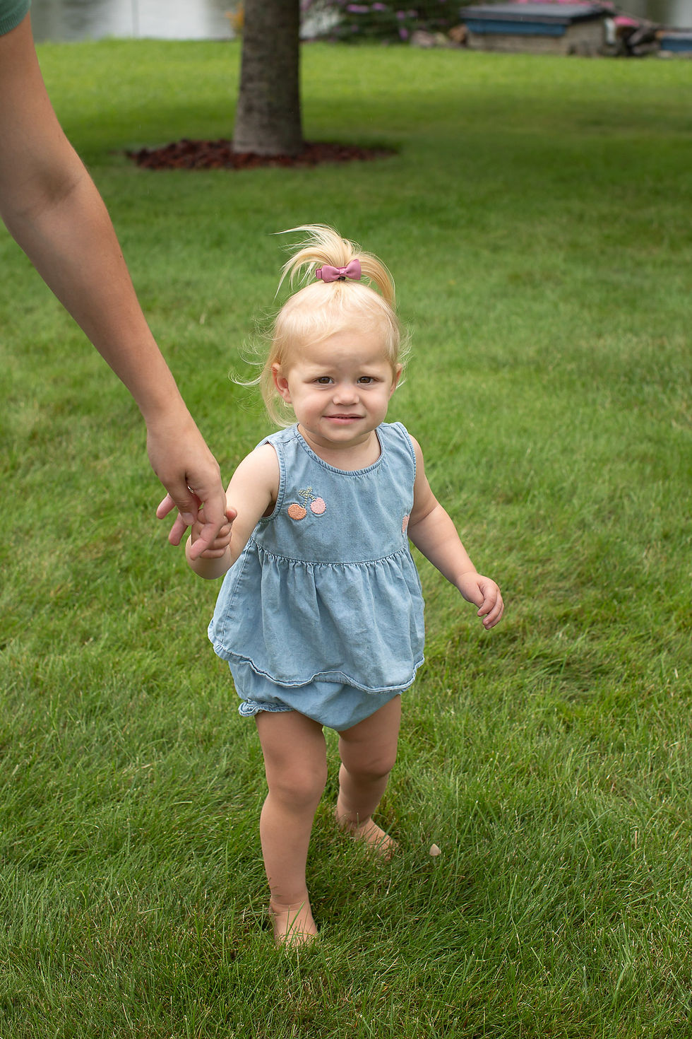 Little girl walking barefoot through the grass during family photos at Sand Point in Caseville Michigan