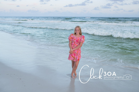 Kids delight in chasing the incoming waves on the shore, their thrill captured in full motion at sunset.