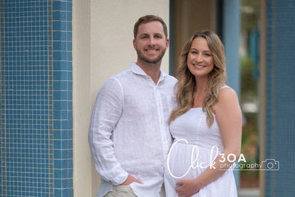 The couple chews forward, their hands forming a heart in this heartfelt 30A Maternity Portraits capture.