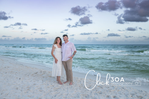 The parents share a moment of laughter as they play in the sand, framed by the golden hues of sunset—an enchanting scene by a 30A Photographer.