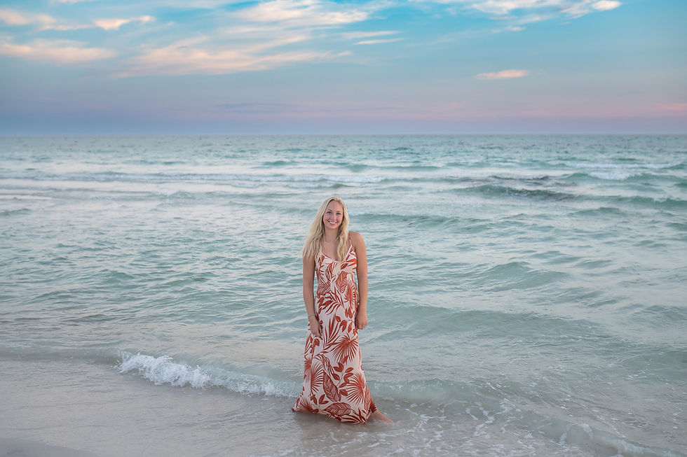 Senior portrait session on 30A beach featuring a Biloxi high school senior styled in a luxury designer outfit at sunset.