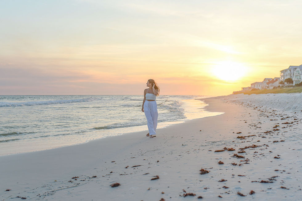 Bride-to-be walking barefoot along the beach toward the sunset during a pre-wedding portrait session