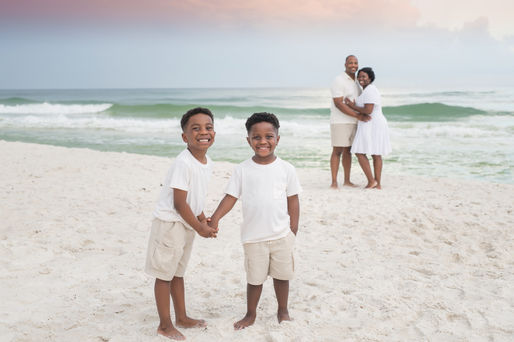 Family embracing at sunset in a 30A Photo Mini Session; book memorable family portraits while on 30A and choose Click 30A Photography, an experienced and professional photographer.