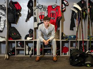 Senior Portraits showcasing a hockey senior with his medal around his neck, captured by Envisions Photography Studio.