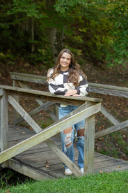 Michigan Senior Portraits Photographer captures a senior girl in a flowing dress beneath tall oaks at the Park in Caro, Michigan.