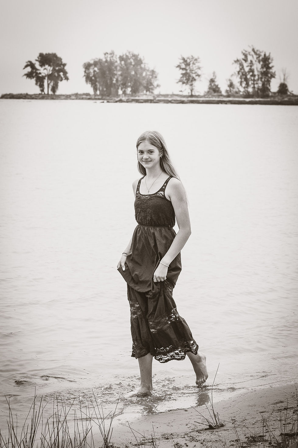 Medium shot of the student smiling softly while sitting near the wooden park structures at Stafford County Park