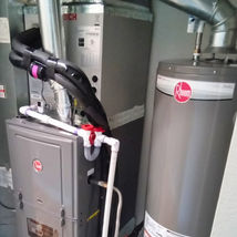 HVAC system featuring a Rheem water heater and furnace installed in a clean utility space.