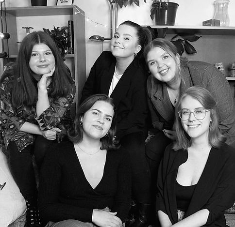 A group company photo of five young women smiling.