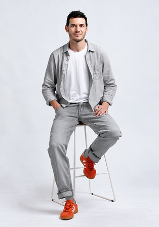 Portrait studio d’un homme en gris et orange.png