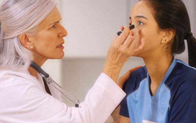 "Una doctora realiza una prueba de conmoción cerebral, iluminando los ojos de una paciente con una pequeña linterna. La médica está enfocada en observar la respuesta pupilar de la paciente, que está sentada frente a ella. La escena muestra un entorno clínico con equipo básico para exámenes neurológicos." Un test de conmoción cerebral (o "concussion test" en inglés) es una evaluación médica diseñada para diagnosticar si una persona ha sufrido una conmoción cerebral.