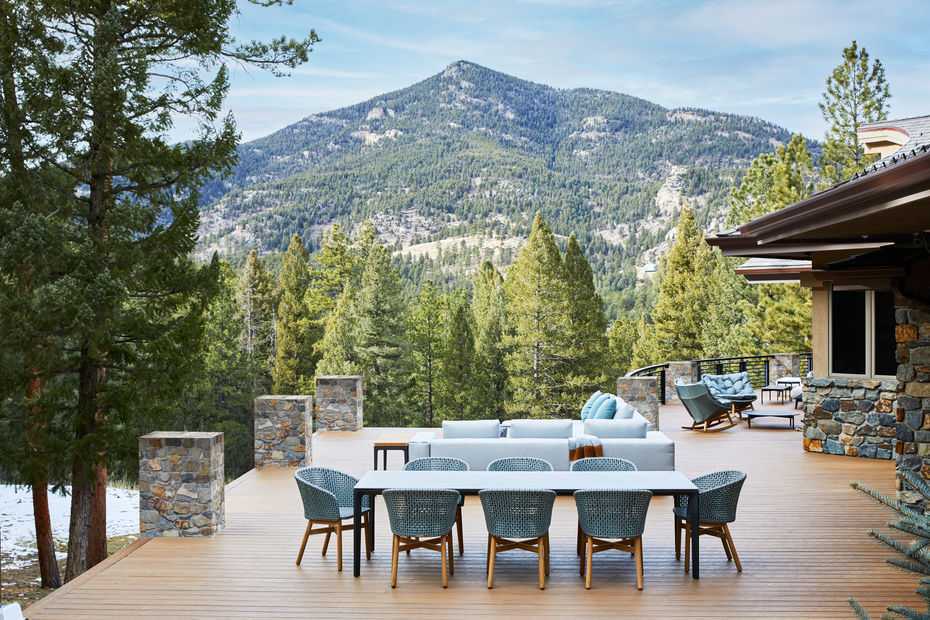 Expansive Colorado deck with woven dining chairs cushioned lounge seating and mountain views