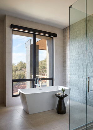 Serene Sedona bath with freestanding tub textured tile wall and floor to ceiling window views