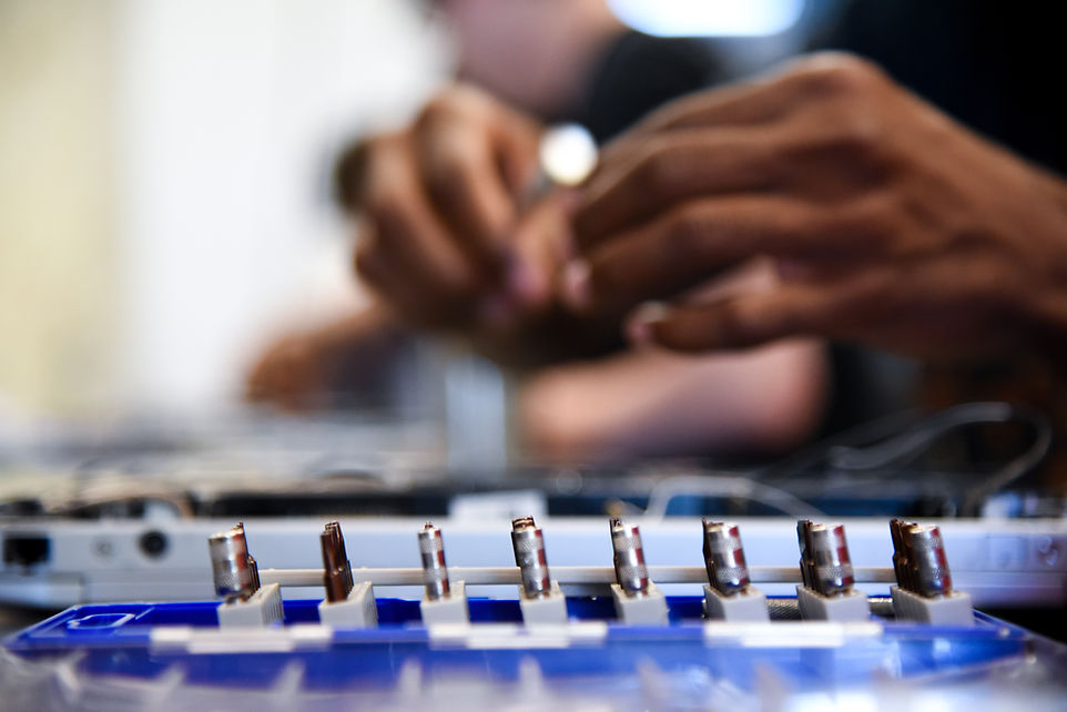 Hands performing Tech+ training on hardware components.