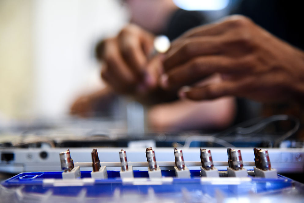 Hands performing Tech+ training on hardware components.