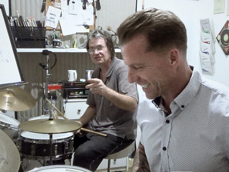 Adult student laughs while taking private drum lessons at Saint
Louis Drum Lessons. Steve Lord interjects advice.