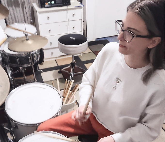 Adult female drum student concentrates on a drumset rhythm at Saint Louis Drum Lessons at 63125